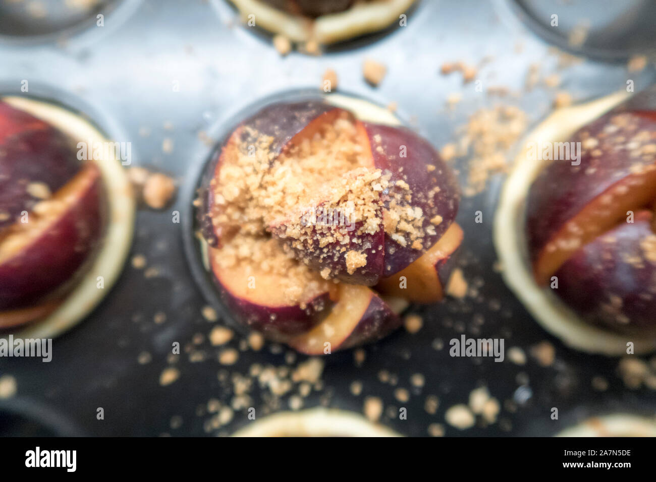 Prugna dolci con i biscotti sminuzzati pronto per essere cotto al forno Foto Stock