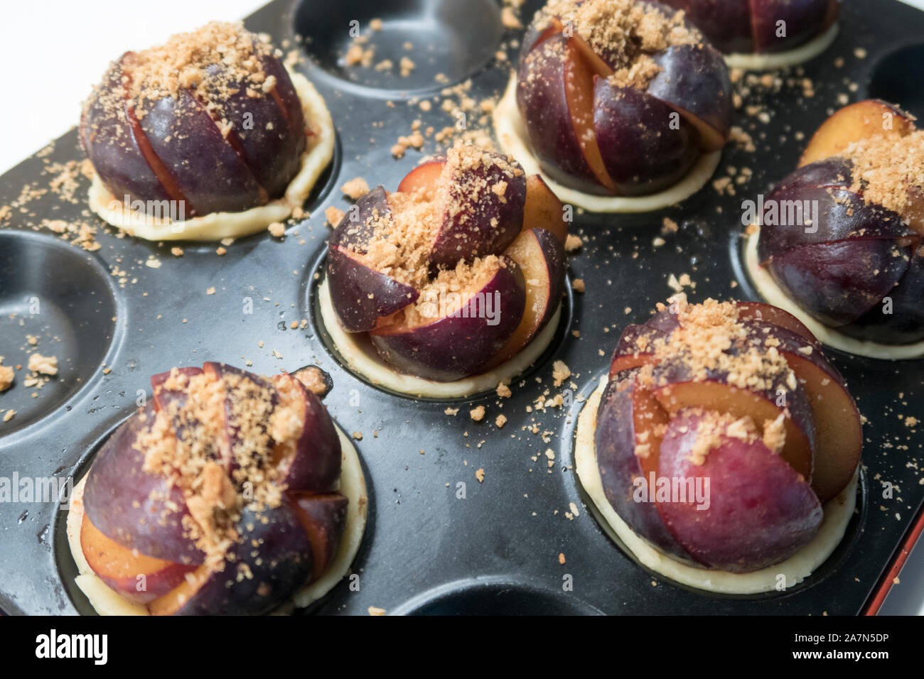 Prugna dolci con i biscotti sminuzzati pronto per essere cotto al forno Foto Stock