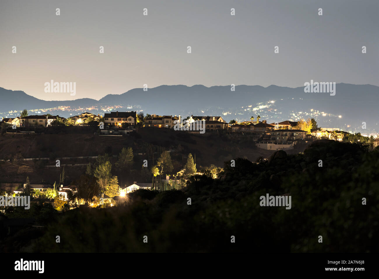 Vista notturna di grandi case in collina nel West Hills zona di Los Angeles, California. Il Santa Monica Le montagne sono in background. Foto Stock