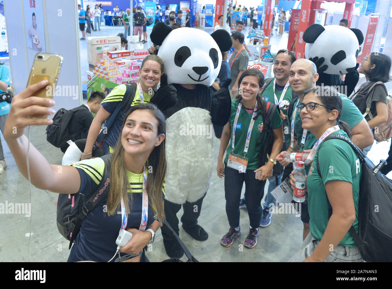 Un ospite interagisce con un lavoratore cinese vestito di panda gigante costume durante il mondo 2019 la polizia e i Vigili del Fuoco Giochi di Chengdu, a sud-ovest della Cina di Foto Stock