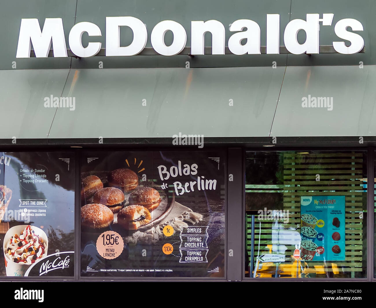 Coina, Portogallo. La vetrina del ristorante McDonalds e pubblicità McCafe una pasta dolce chiamato Bolas de Berlim, un regionale specialità portoghesi. Foto Stock