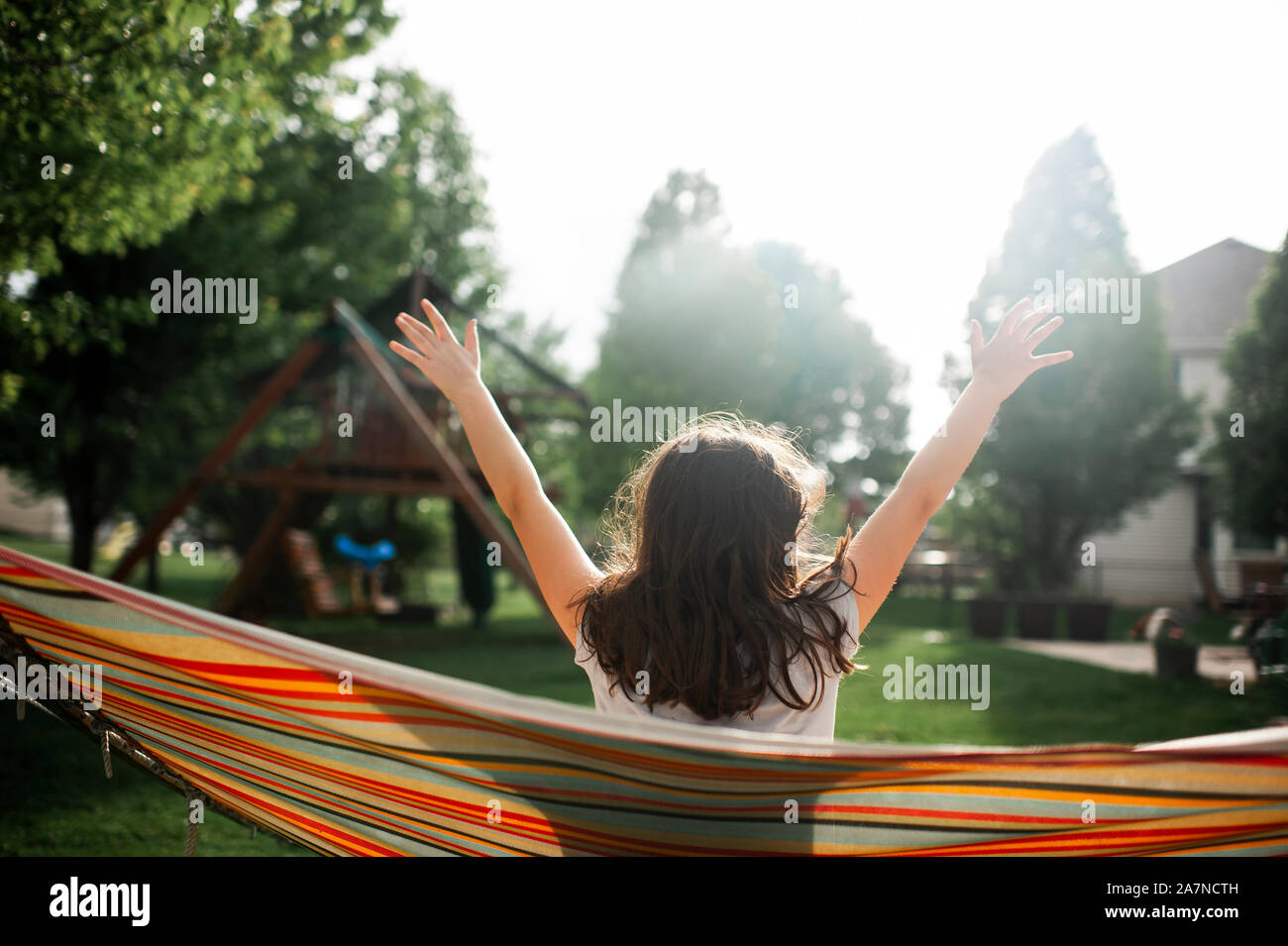 Tween girl prendendo una pausa mentre oscillanti in amaca in cortile Foto Stock