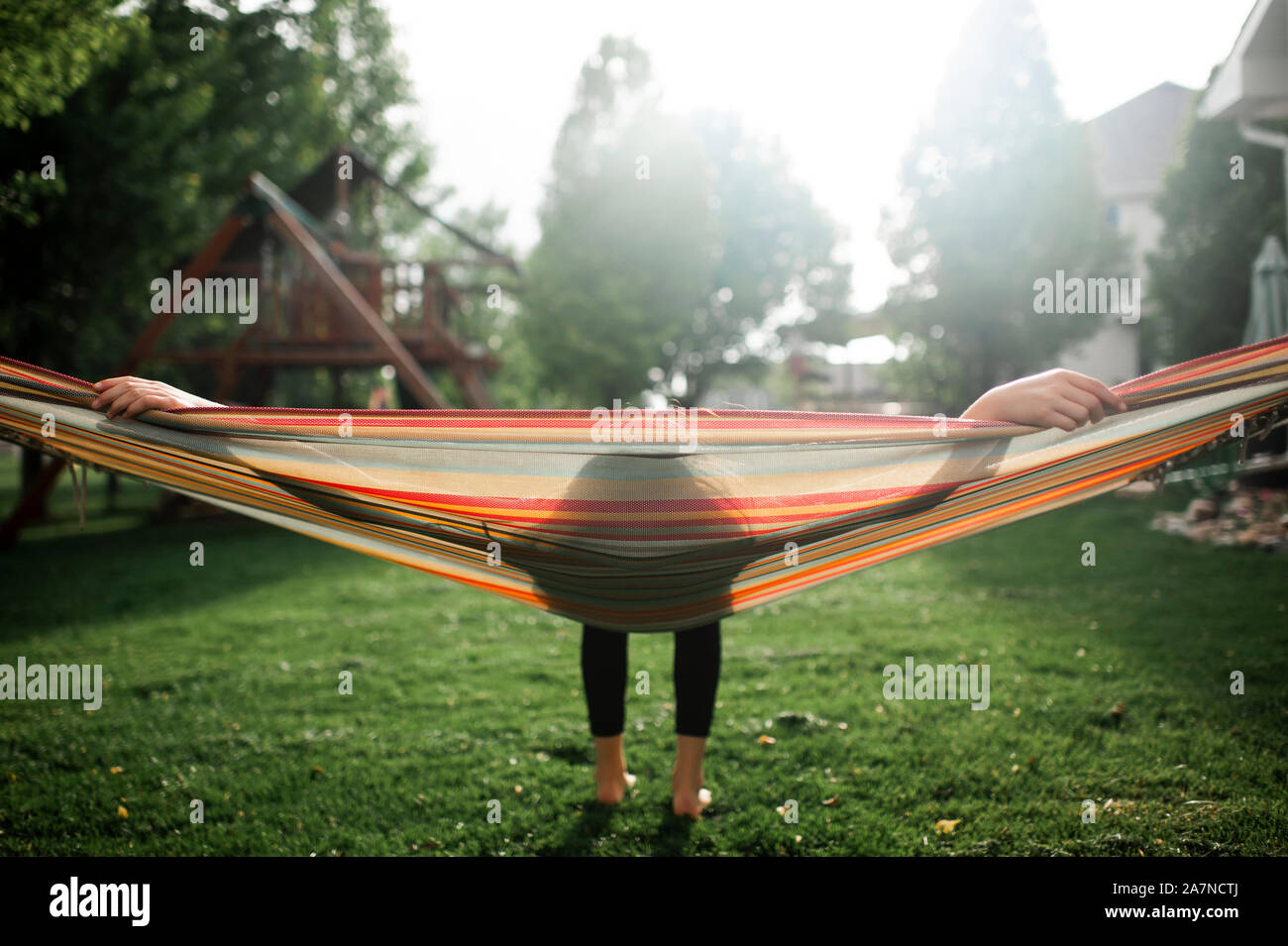 Tween girl prendendo una pausa mentre oscillanti in amaca in cortile Foto Stock