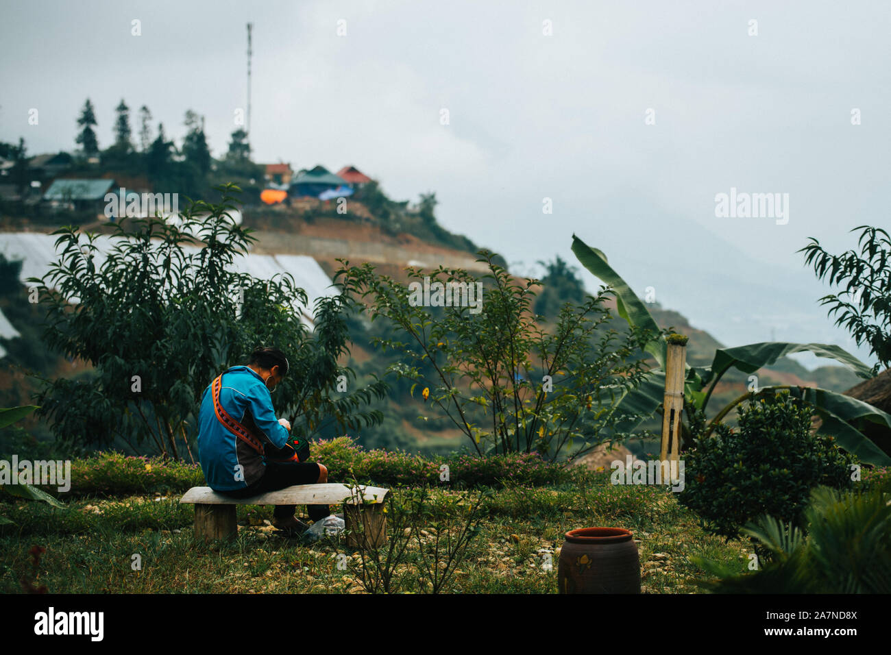 Un locale donna vietnamita produce abiti circondato da terrazze di riso nella piccola città di montagna Sapa nelle montagne a nord dell Indocina Foto Stock