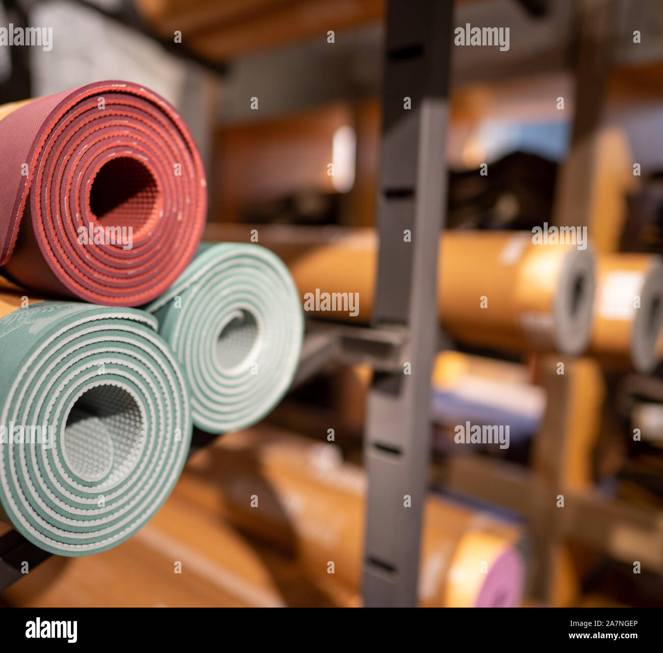 Rotoli di Materassini da yoga accatastati nel magazzino di stoccaggio stanza sul retro Foto Stock