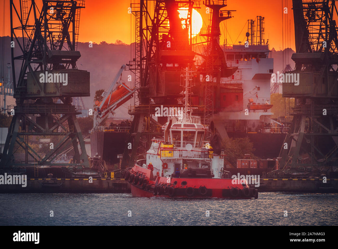 Colorato tramonto sul porto di mare e le gru industriali, Varna, Bulgaria Foto Stock