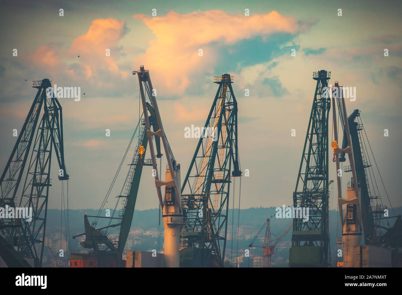 Tramonto sulla gru industriali a livello commerciale porto di mare della città di Varna, Bulgaria immagine Foto Stock