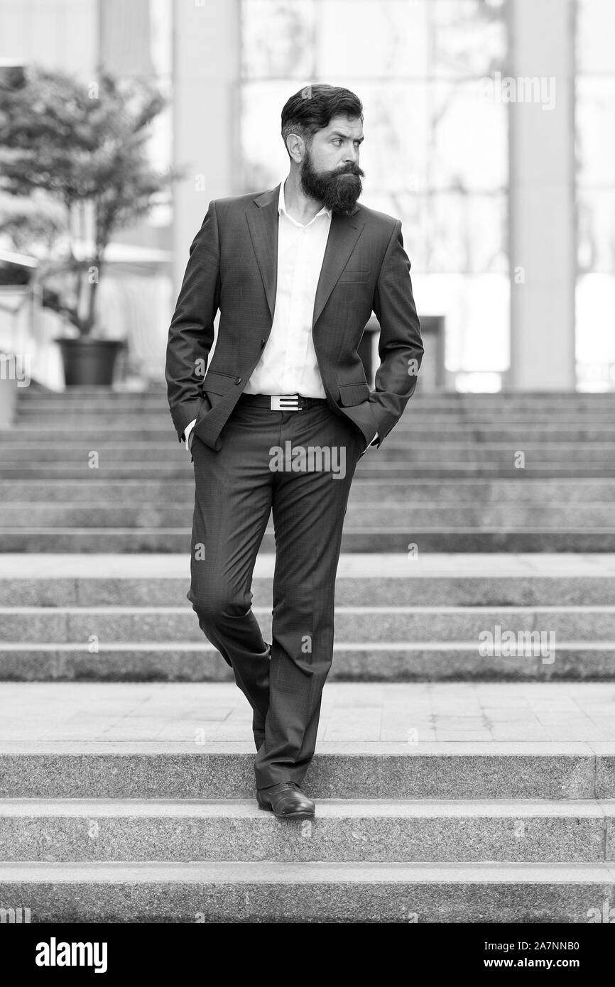 Uomo d'affari nella città moderna. Inizio della giornata lavorativa. Motivati per il successo. Lavoratore di ufficio con fiducia il passo sulle scale. Fondatore business di successo. Conquista il mondo del business. Uomo Barbuto di andare a lavorare. Foto Stock