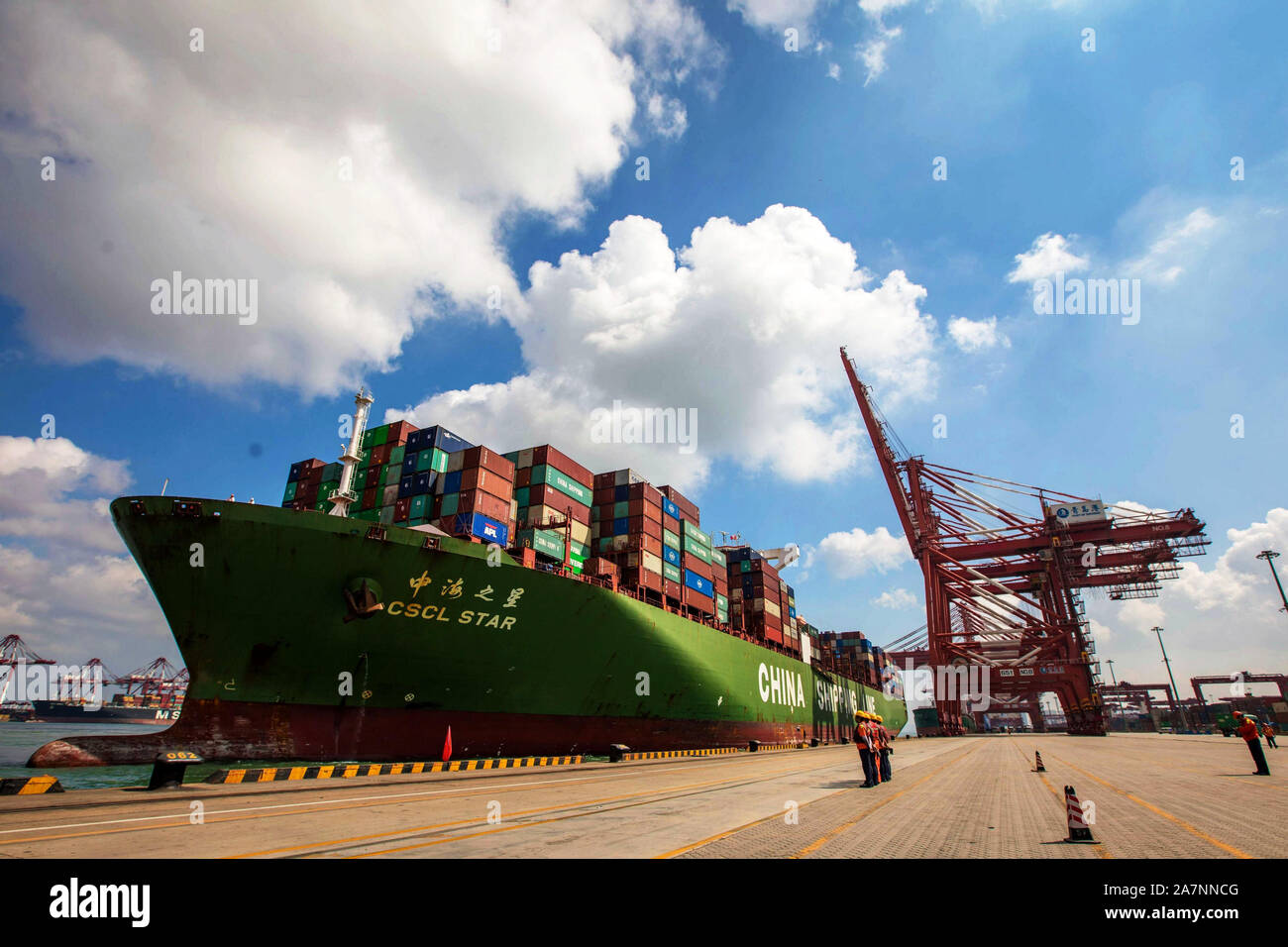 Una nave da carico cinese linea marittima caricato con contenitori per essere spediti all'estero posti barca su una banchina del porto di Qingdao nella città di Qingdao, est della Cina di Foto Stock