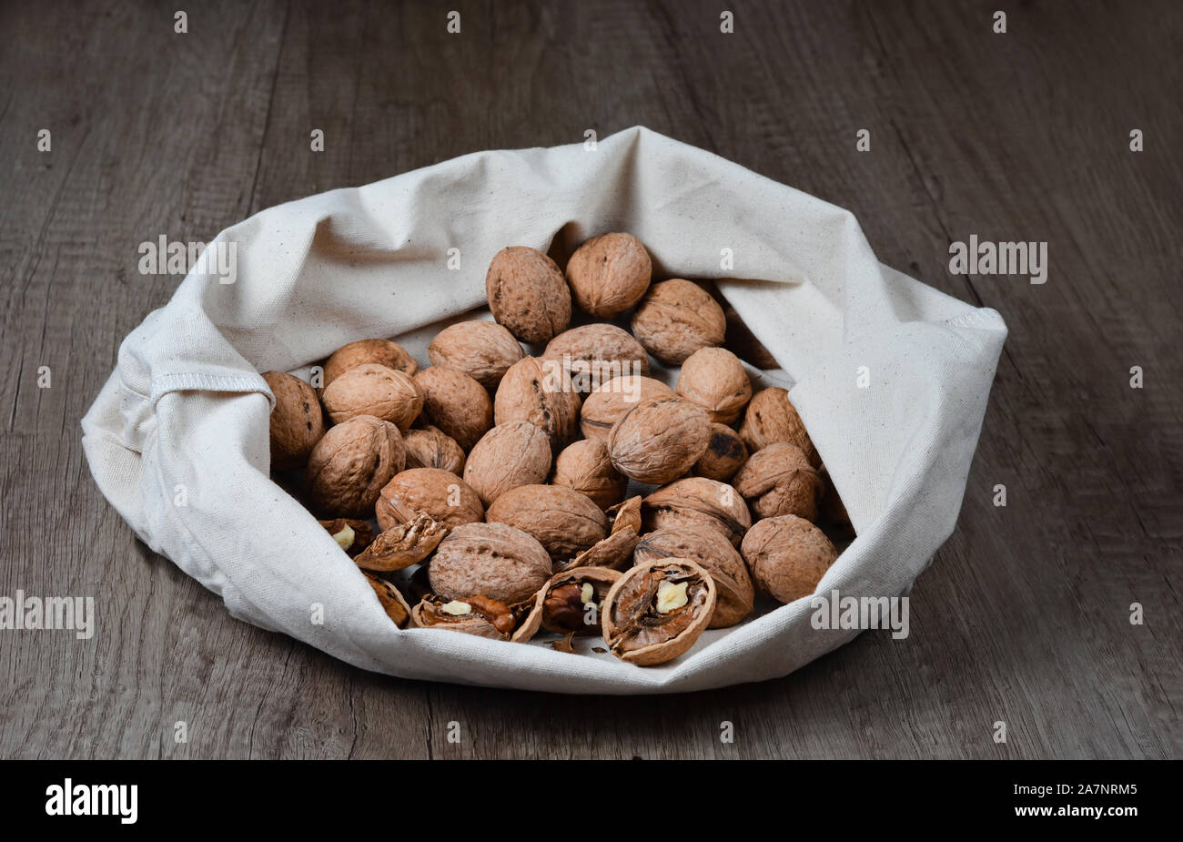 Tutta crepata e noci in un bianco rustico canapa organico sacchetti. Foto Stock