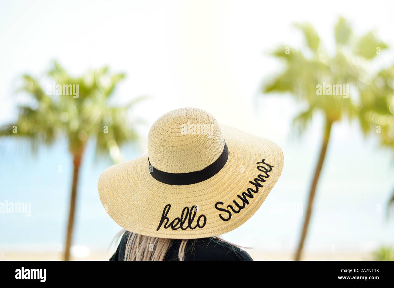 Close-up di giovani donne maried avente un cappello di paglia sulla sua testa rilassante per la nostra luna di miele in un hotel con balcone sulla riva del mare. guardando il mare Foto Stock
