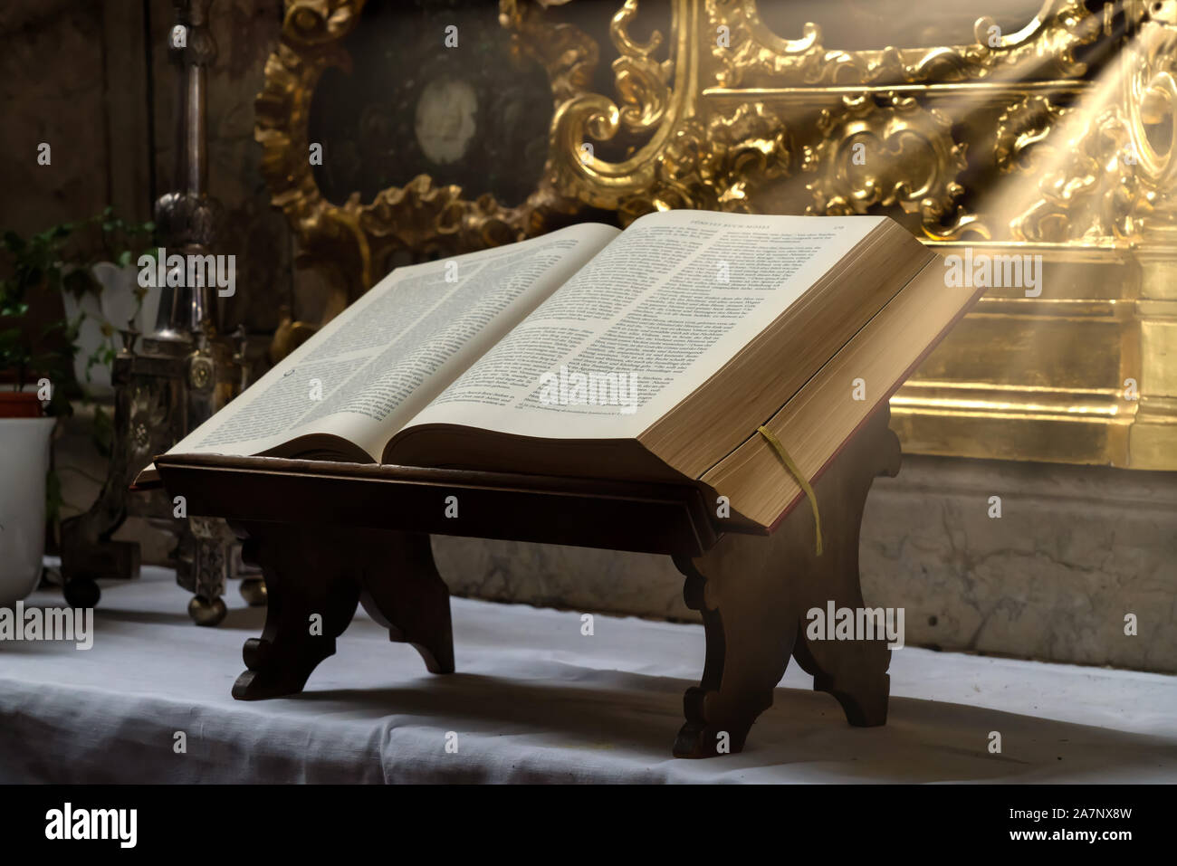 Aprire la bibbia illuminata dai raggi di sole su un altare Foto Stock
