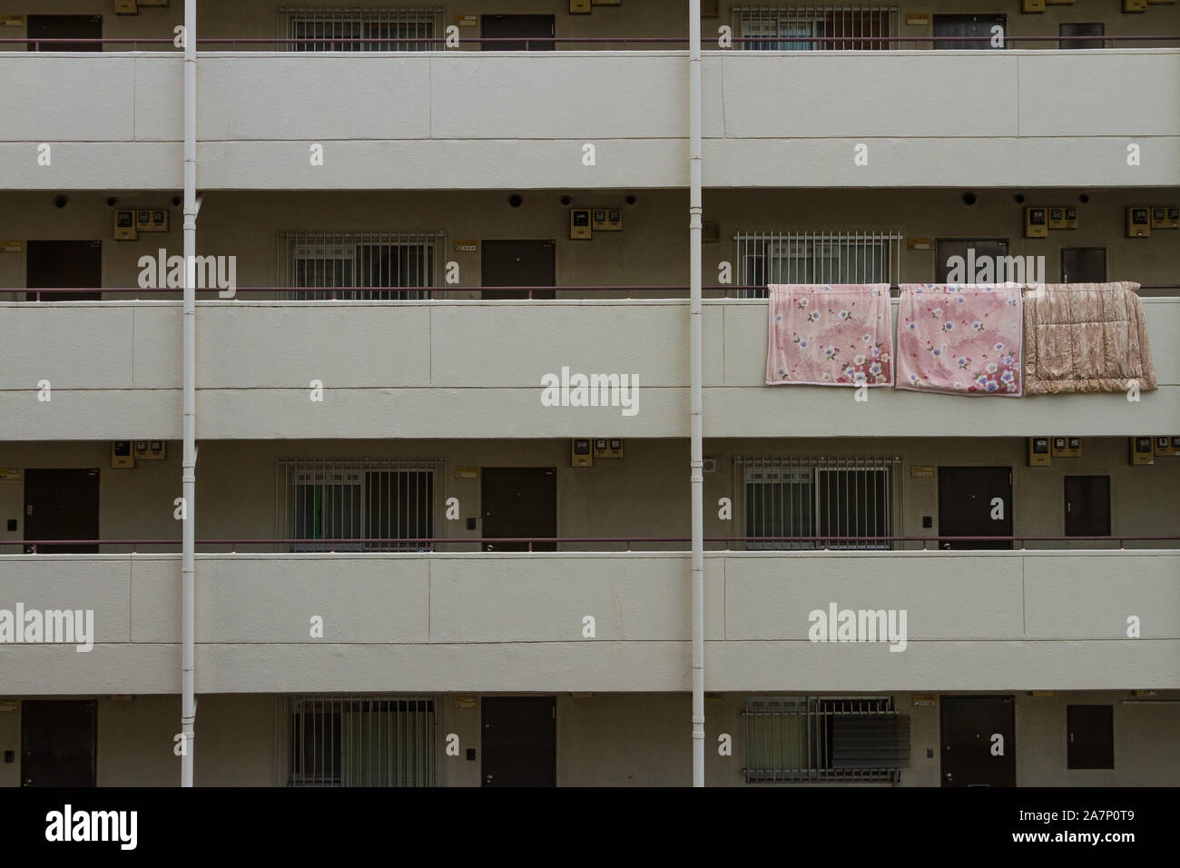 Coperte appese all'aria sul balcone di un condominio a Omori, Tokyo, Giappone. Foto Stock