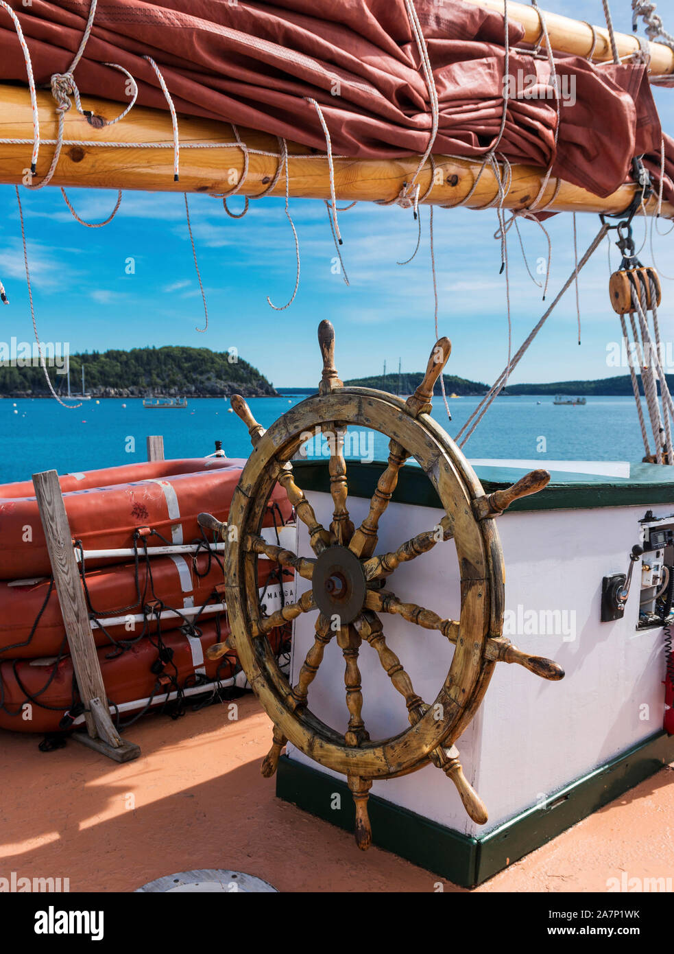 Foto scattata da una barca a vela in legno mentre galleggianti intorno Bar Harbor, Maine con il porcospino isole in vista sotto la vela e dietro il steeriin Foto Stock