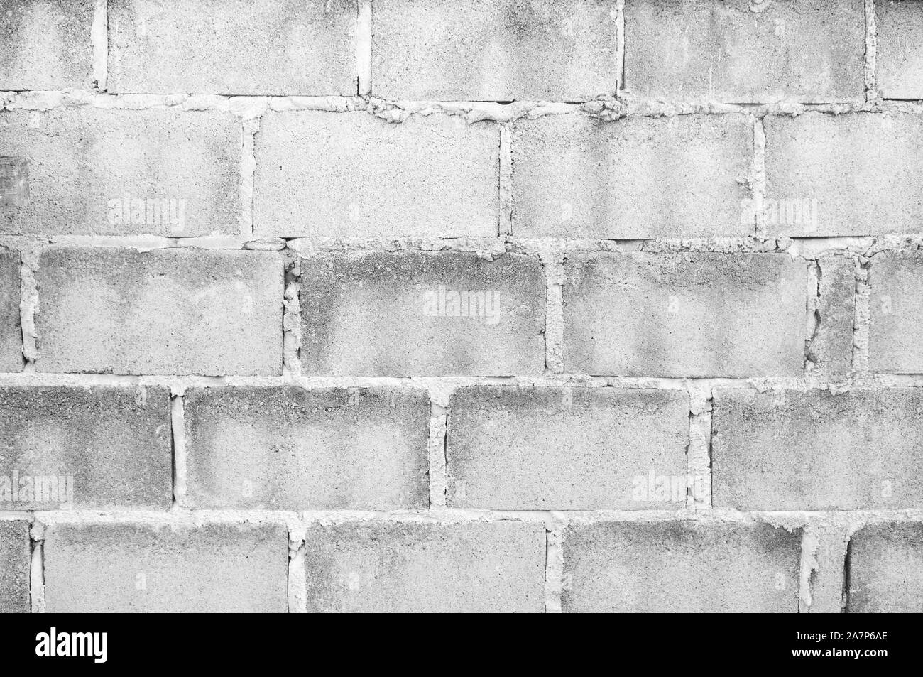 Grigio Luce colorata tono grungy ruvide testurizzate vecchio blocco di calcestruzzo muro di mattoni sfondo Foto Stock