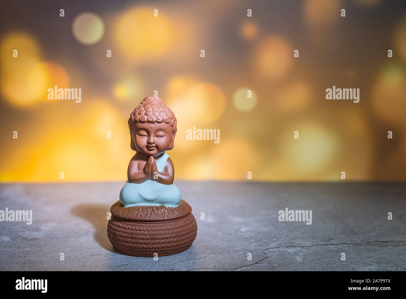 Monaco seduto pregando statua casa decorazione ornamento. Copia vuota spazio per il testo. Foto Stock