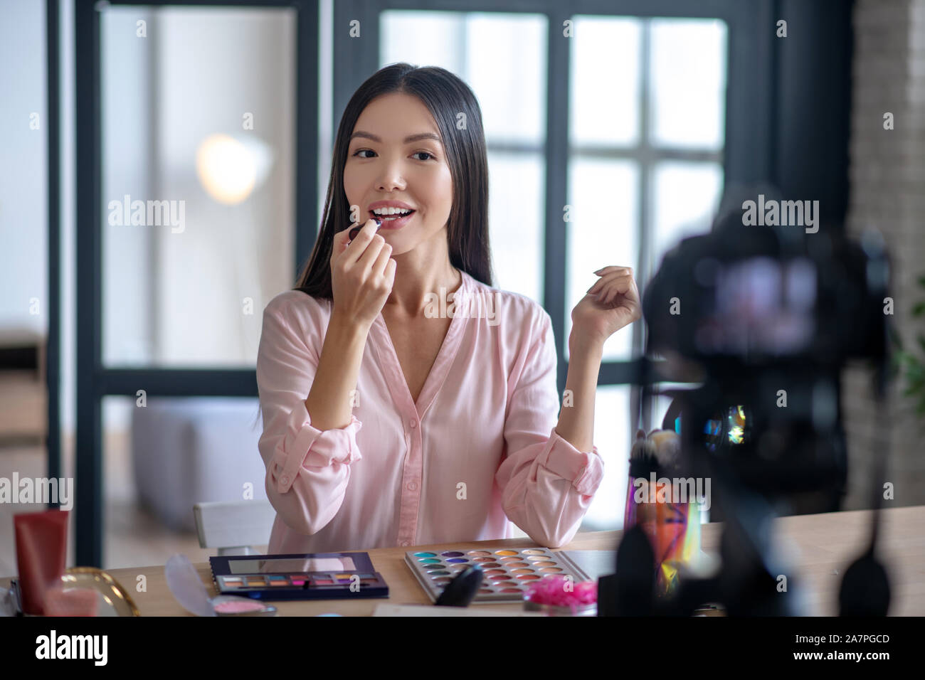 Blogger di mettere il rossetto durante le riprese di makeup tutorial Foto Stock