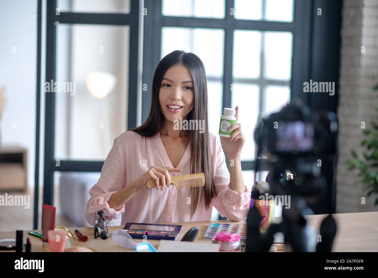 Bellezza blogger spazzolare i capelli e che raccontano le vitamine Foto Stock