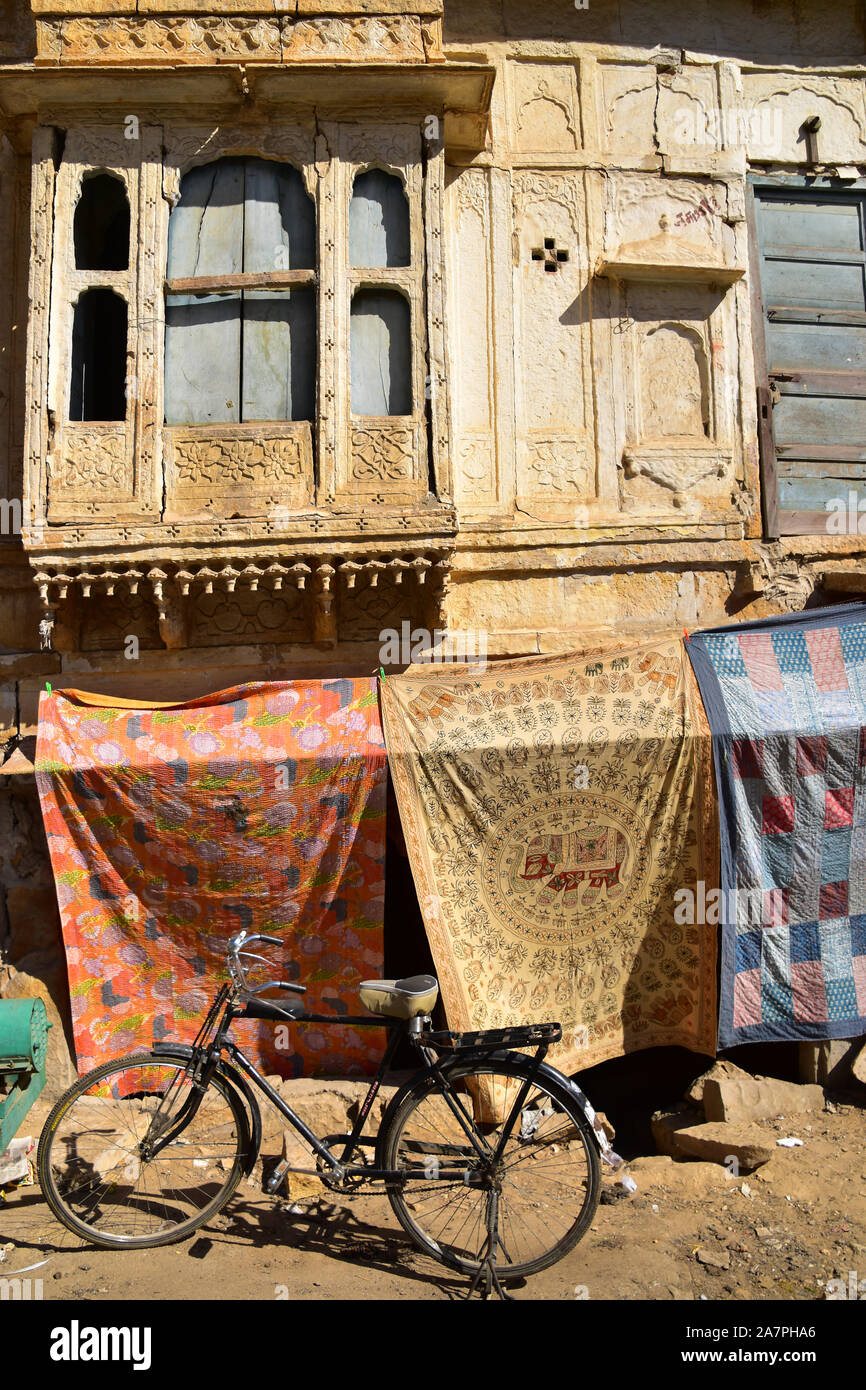 Tappeto indiano shop sotto ornato oro edificio in arenaria, Jaisalmer, Rajasthan, India Foto Stock