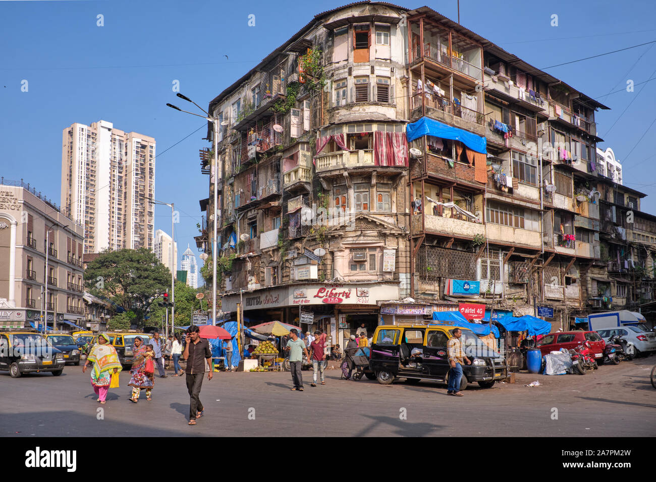 Un tipico vecchio e decrepito edificio residenziale in corrispondenza di una intersezione stradale di Grant Road, Mumbai, India, costituito da numerose proprietà individuale appartamenti Foto Stock