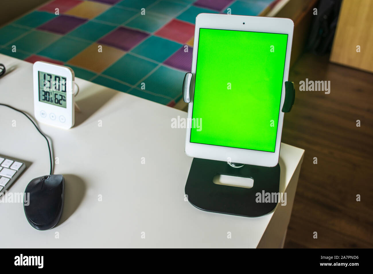 Lavorare da casa mobile tablet, il mouse e il LED orologio con schermo verde sul desktop Foto Stock