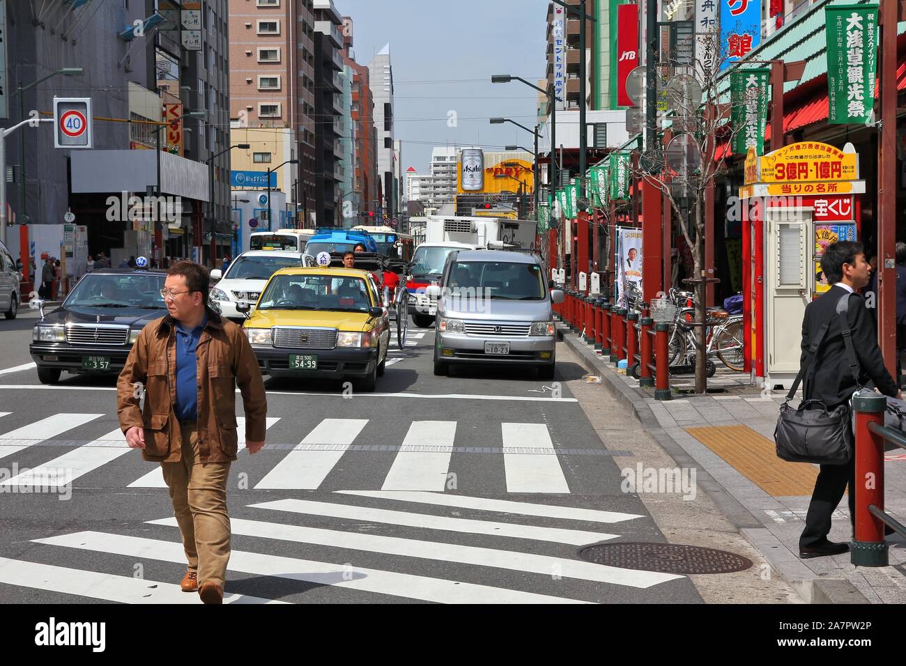 TOKYO, Giappone - 13 Aprile 2012: uomo attraversa Street nel quartiere di Asakusa, Tokyo. Asakusa è uno dei più antichi quartieri di Tokyo, la città capitale e ampia Foto Stock