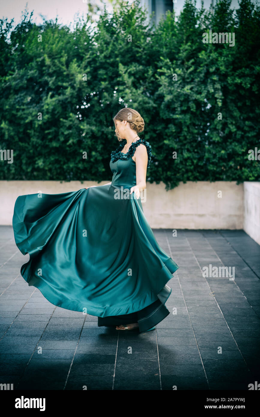 Happy woman dancing in abito da sera all'aperto Foto Stock