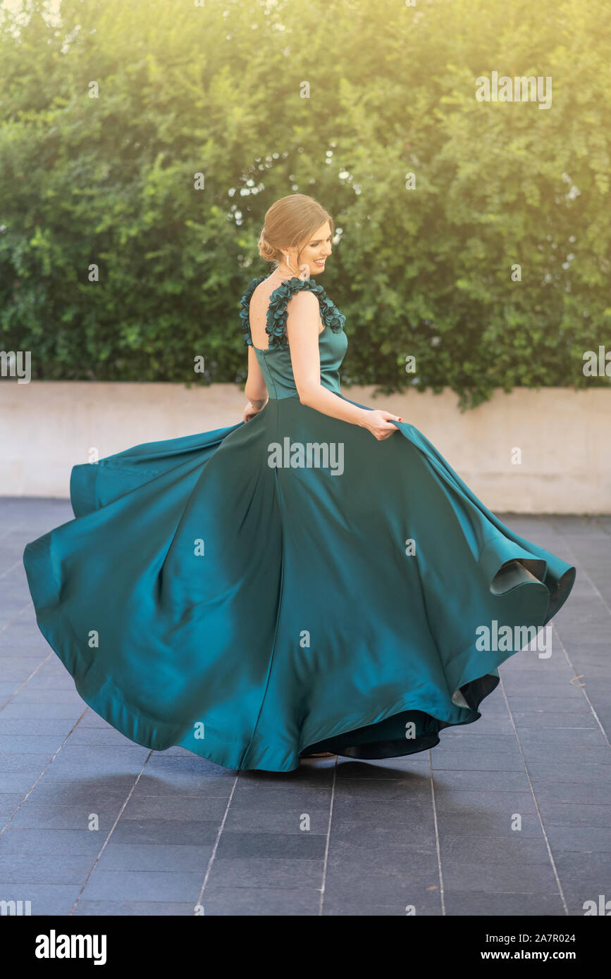 Happy woman dancing in abito da sera all'aperto Foto Stock