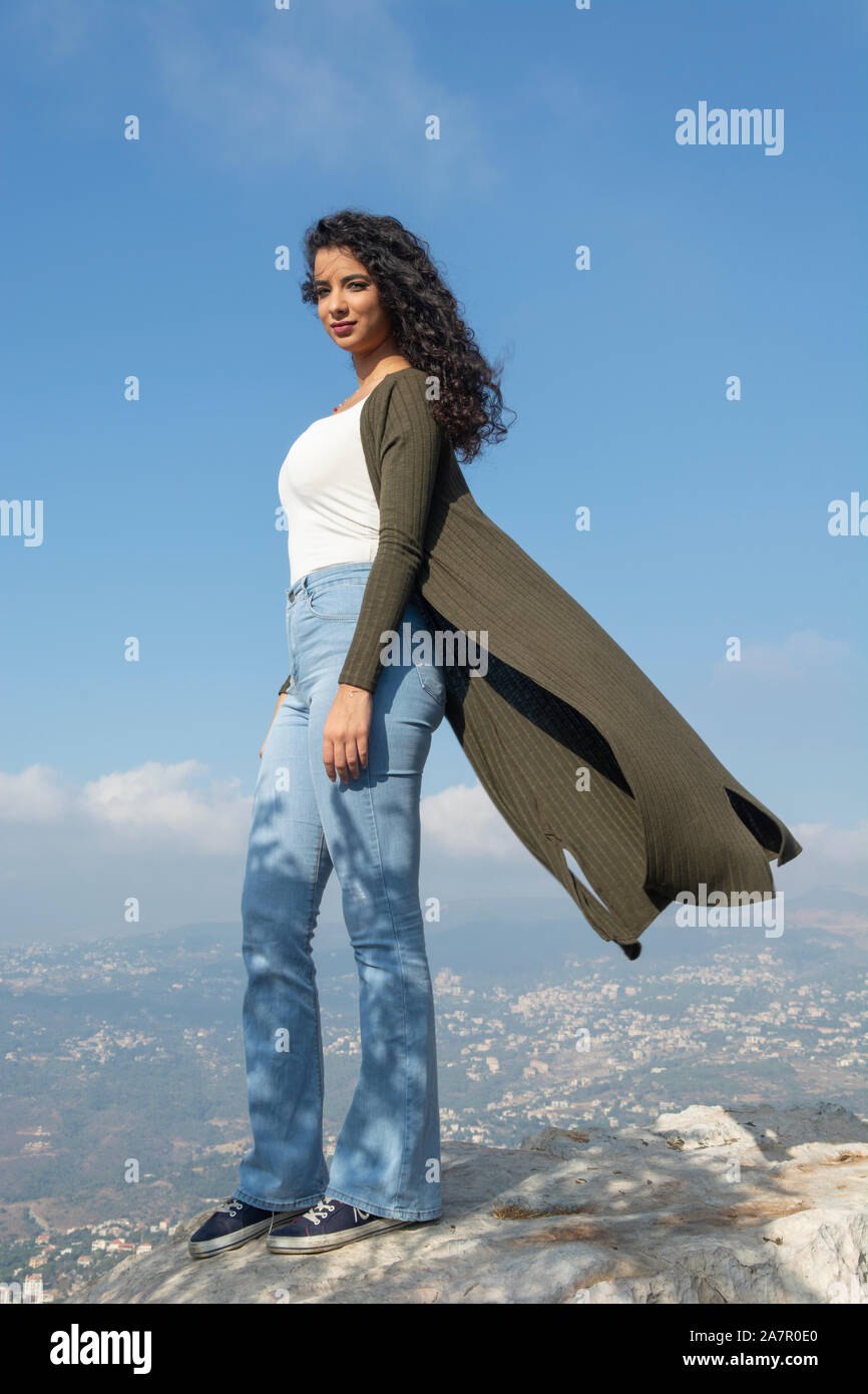 Bella giovane donna in piedi sulla cima della montagna Foto Stock