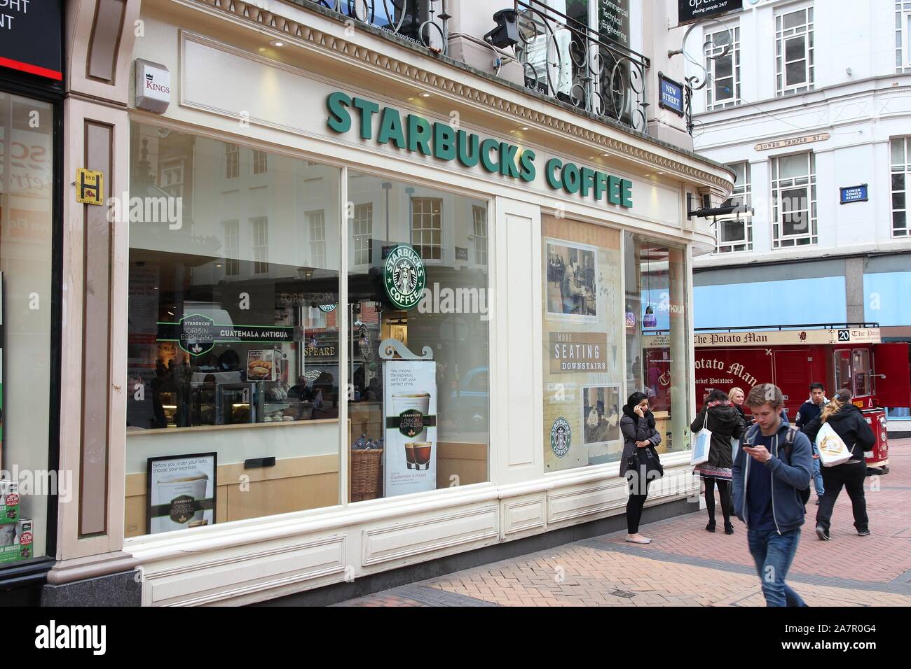 BIRMINGHAM, Regno Unito - 19 Aprile 2013: la gente a piedi da caffè Starbucks Cafe a Birmingham, Regno Unito. Starbucks Corporation opera 23,768 luoghi in tutto il mondo. Foto Stock