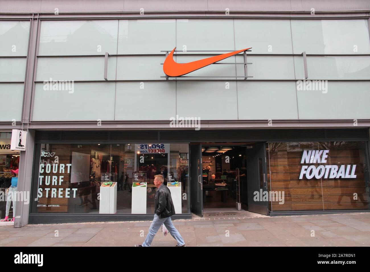 MANCHESTER, Regno Unito - 22 Aprile 2013: uomo cammina da Nike Sport fashion store a Manchester, UK. Nike marca è stata valutata a 19 miliardi di USD nel 2014. Foto Stock