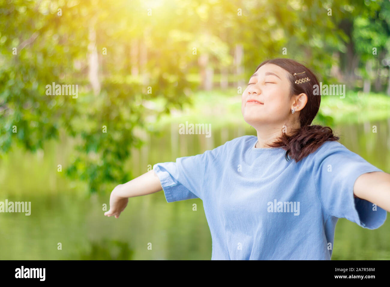 Girl Teen giovane aprire completamente i bracci di respirare fresca e pulita aria di ozono nel verde parco all'aperto Foto Stock