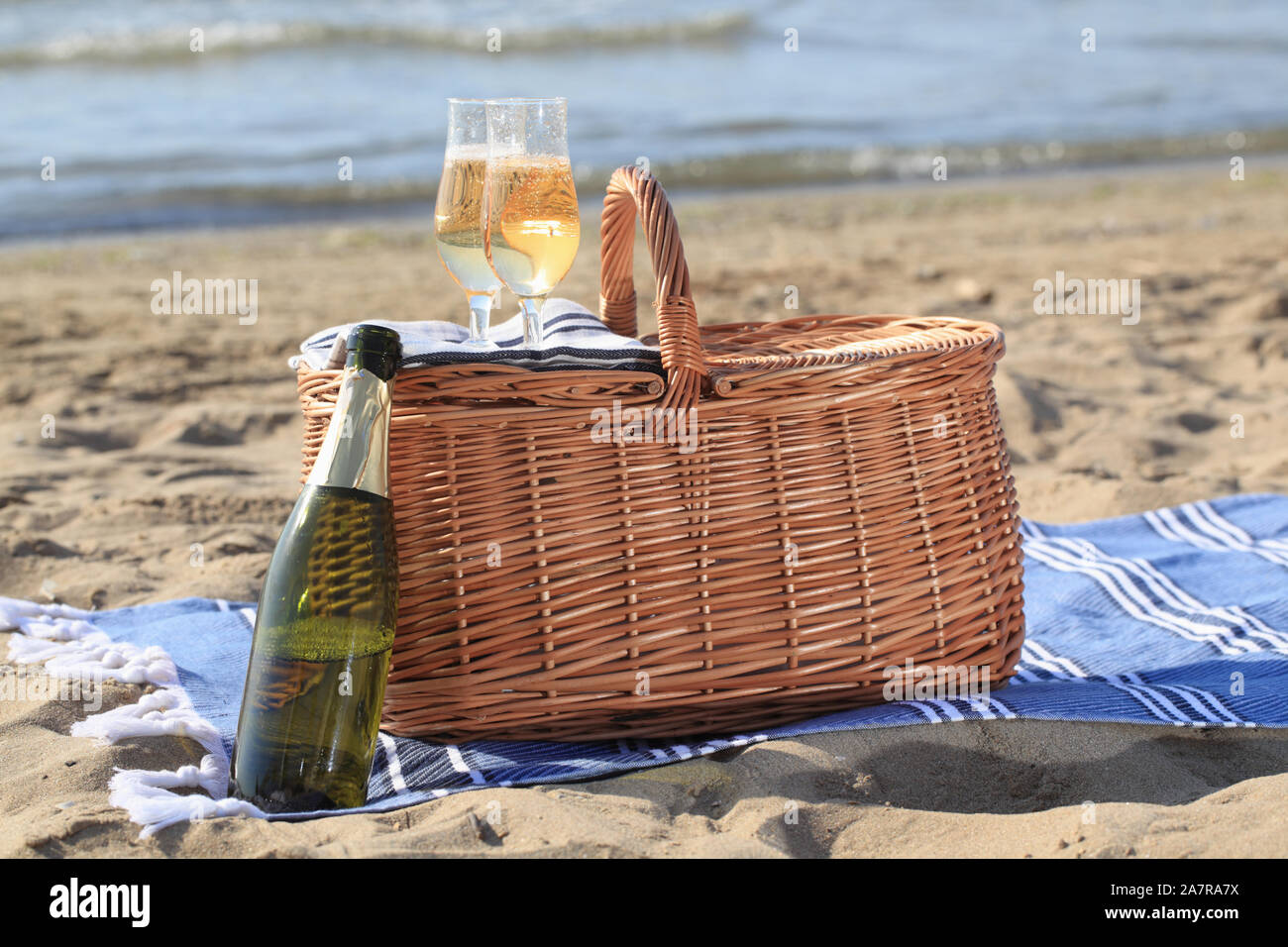 Due bicchieri di champagne su un cestino da pic nic contro la spiaggia di  sabbia e il mare Foto stock - Alamy
