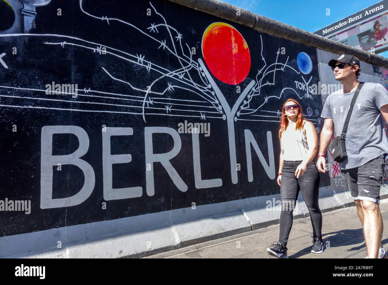 Muro di Berlino, giovani che passano intorno East Side Gallery Germania stile di vita Friedrichshain città strada Berlino persone Foto Stock