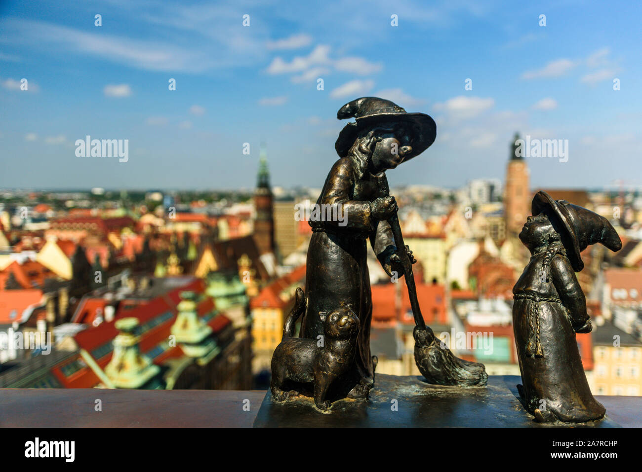 Wroclaw, Polonia - Giugno 2019: vista del centro storico di Santa Maria Maddalena chiesa con due ragazza nano su Witches Bridge. Krasnoludki, gnomi Foto Stock