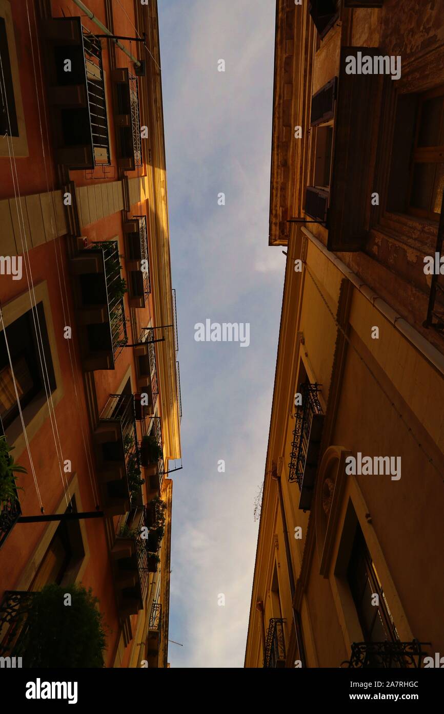 cielo blu con nuvole viste tra due vecchi edifici Foto Stock