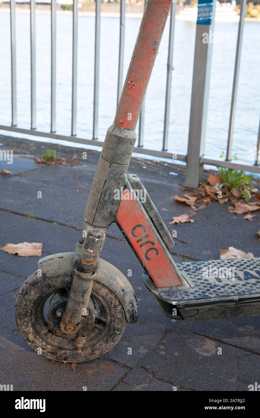 Una sporca Circ scooter elettrico recuperato dal Reno sorge sulle rive del Reno a Colonia, Germania. aus dem Rhein geborgener Circ Elektroscoot Foto Stock