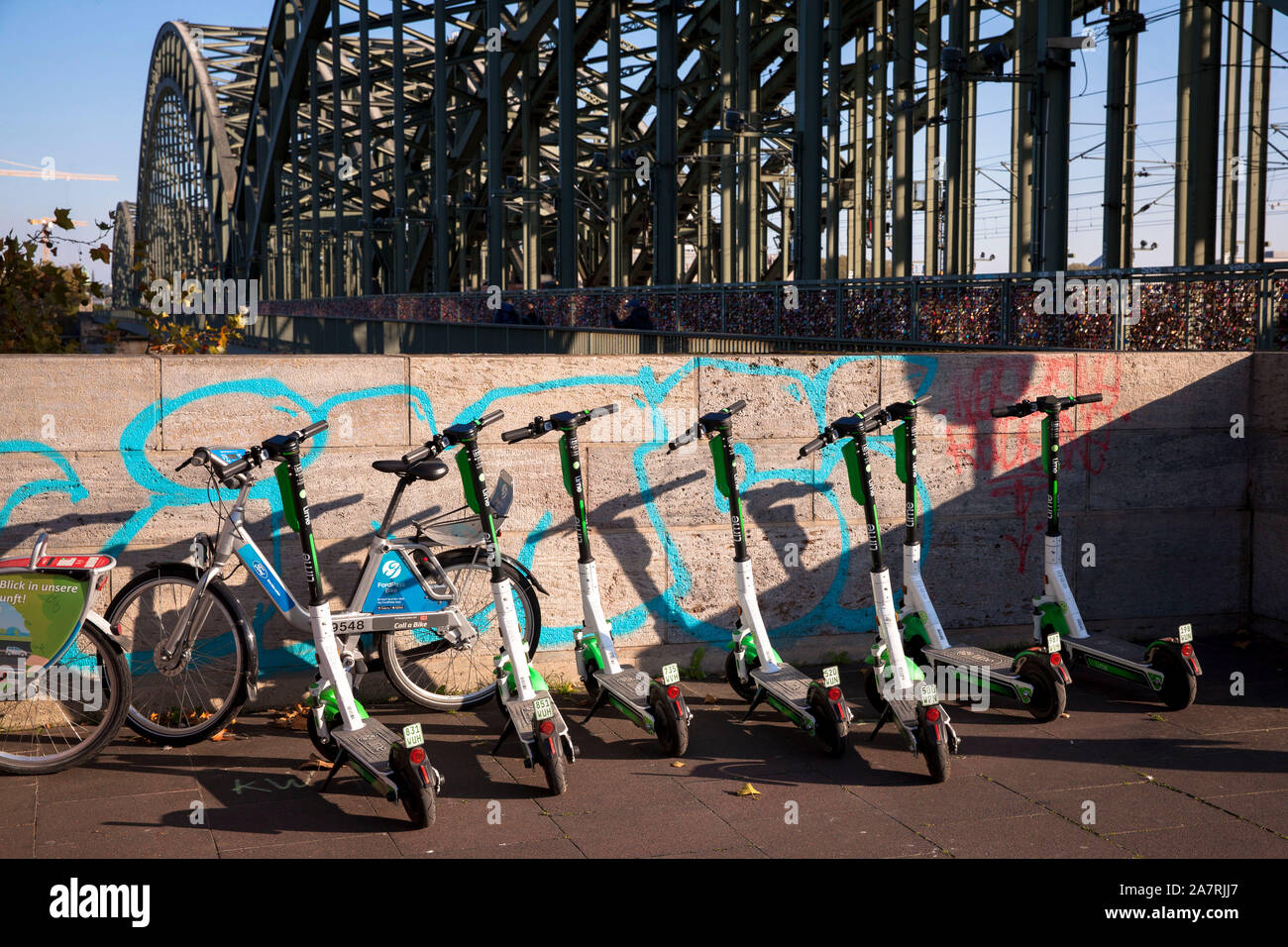 Lime scooter elettrici a noleggio presso il ponte di Hohenzollern, Colonia, Germania. Lime Elektroscooter zum mieten an der Hohenzollernbruecke, Koeln, Deutsc Foto Stock