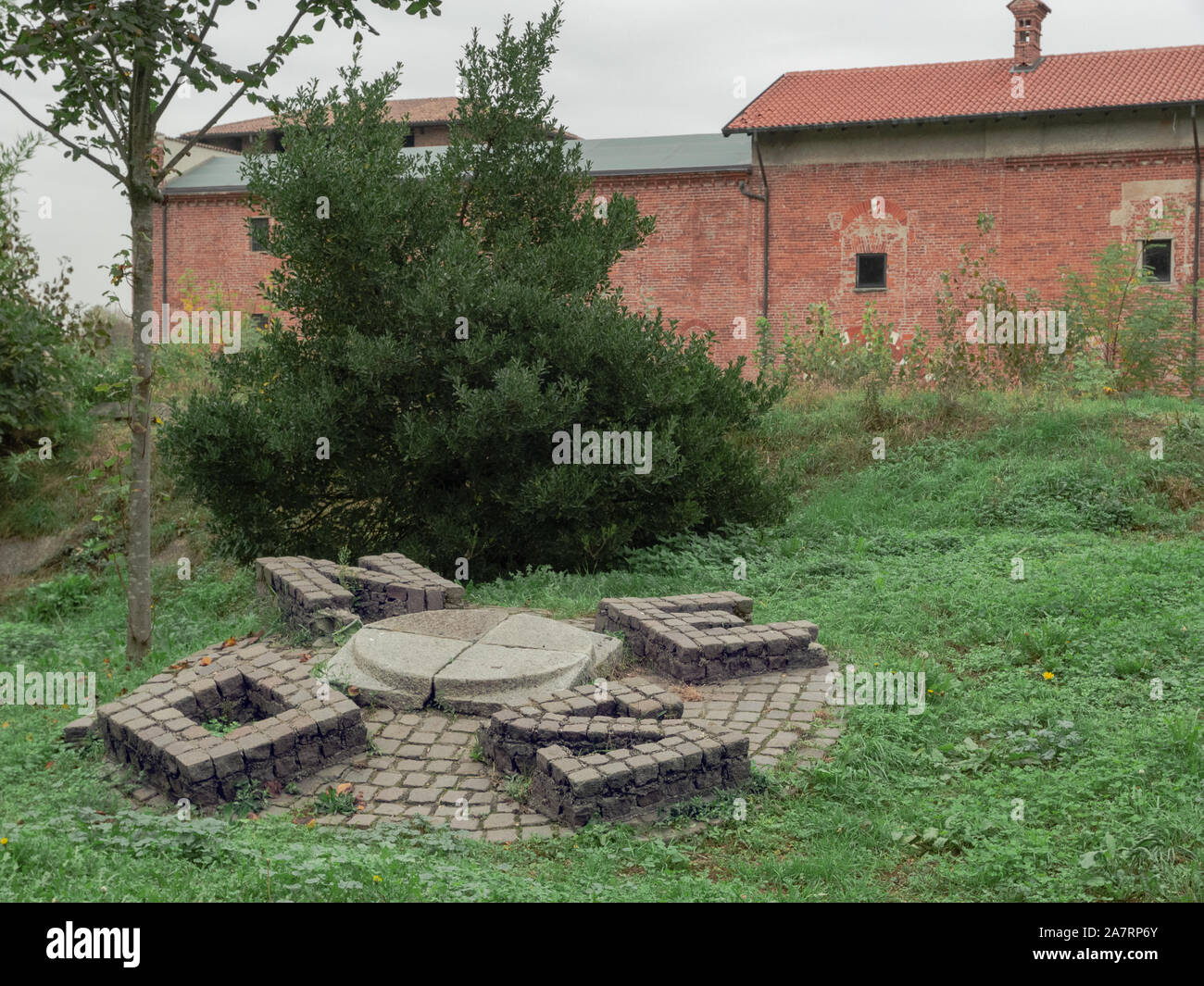 Artefatti di pietra raffiguranti i quattro punti cardinali sul prato di un giardino pubblico Foto Stock