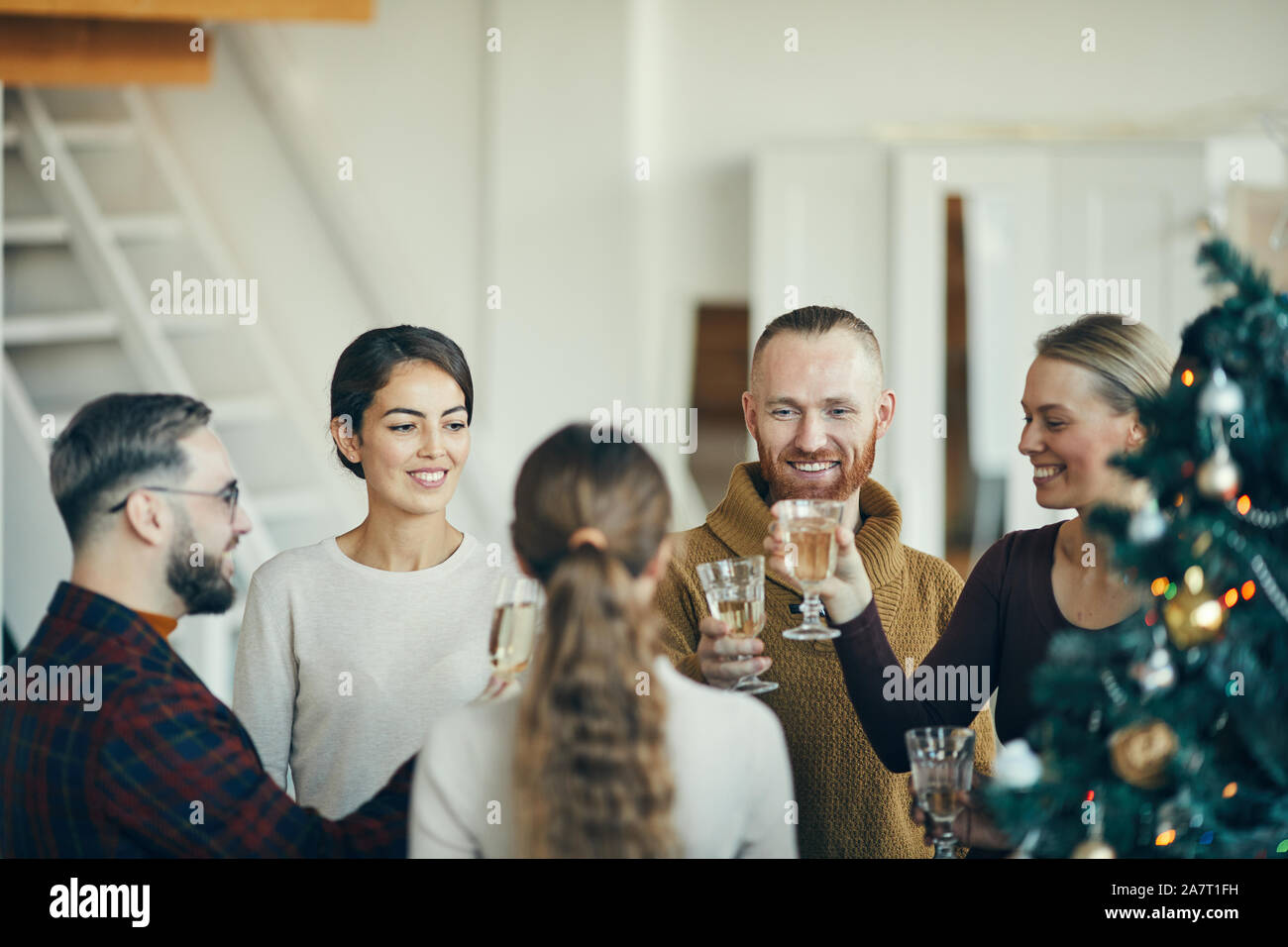 Angolo di alta vista sul gruppo di persone eleganti bicchieri tintinnanti durante la festa di Natale a casa, spazio di copia Foto Stock