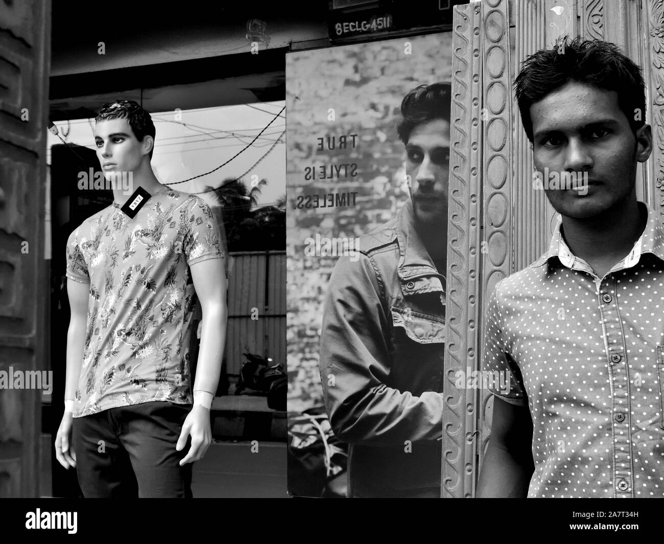 Un uomo cammina da un negozio di moda uomo. Foto Stock