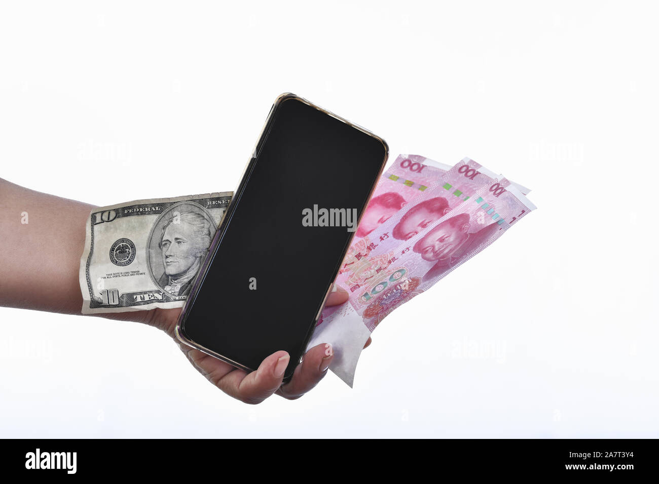 Una mano che tiene un telefono cellulare vicino al yuan e dollaro banconote Foto Stock