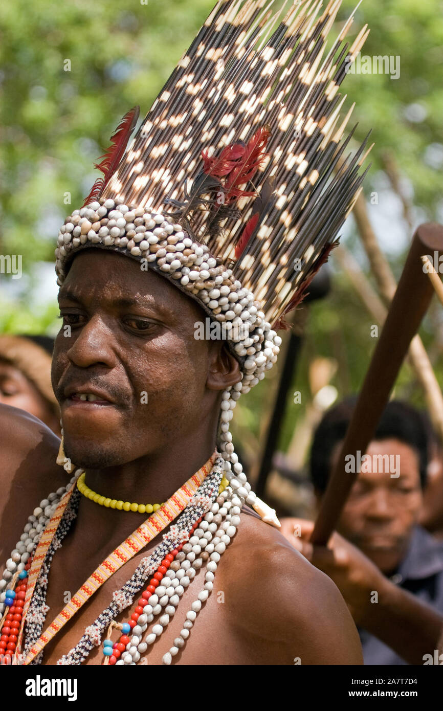 Un uomo Zulu in tradizionale Zulu vestito con una testiera in di porcupine quills e piume rosso dal's Turaco bird ((iGwalagwala). Foto Stock