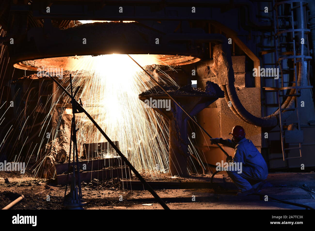 --FILE--un lavoratore cinese elabora le parti in acciaio presso lo stabilimento di Shandong Ferro acciaio Gruppo nella città di Laiwu, est della Cina di provincia di Shandong, 21 aprile 2018. Foto Stock