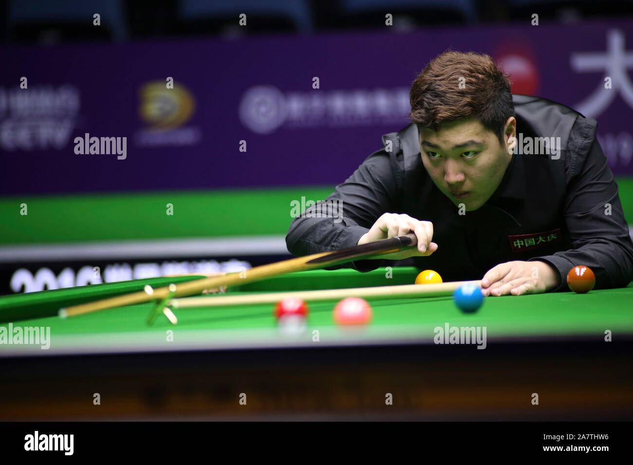 Yan Bingtao della Cina gioca un colpo di Alfie onere di Inghilterra nel heldover corrispondere durante il 2019 World Snooker Campionato Internazionale di Daqing Foto Stock