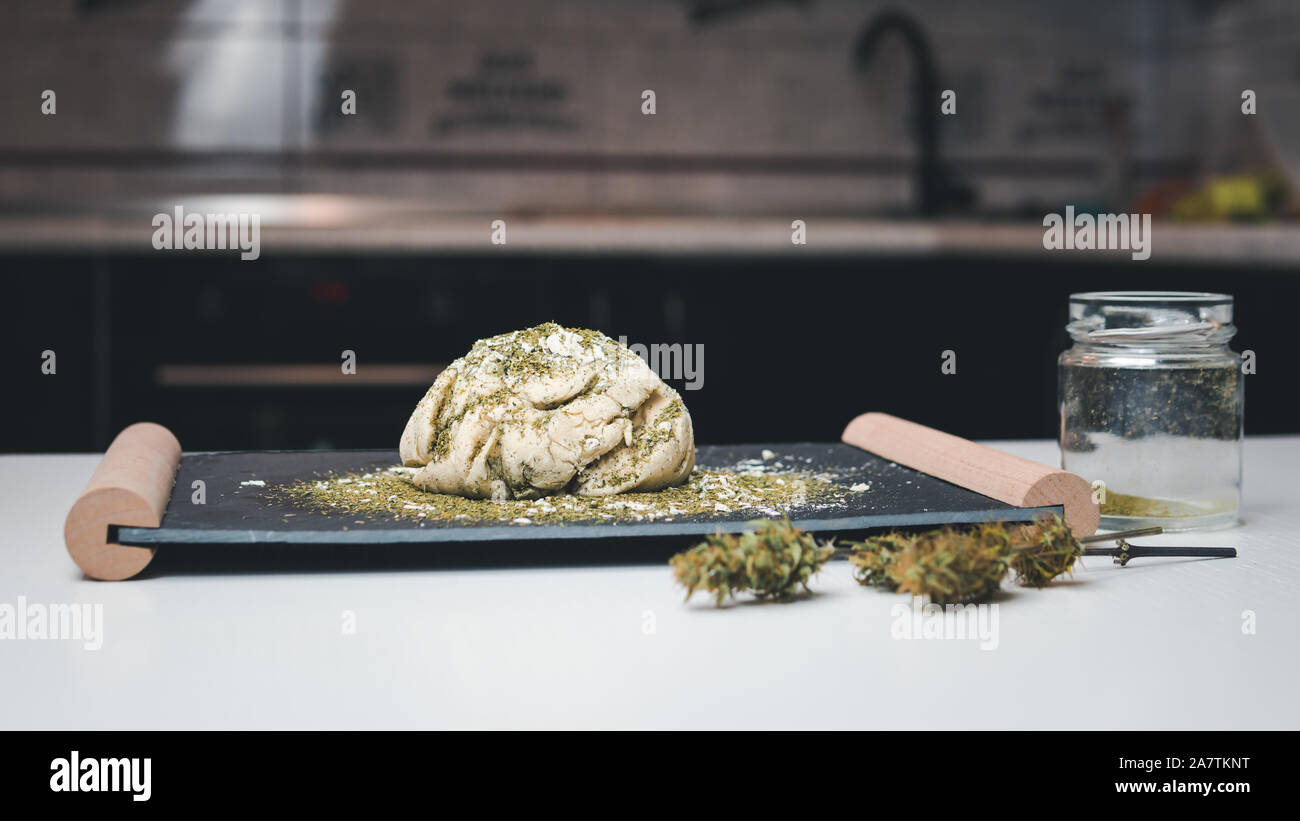 Preparazione per la cottura di canapa o torta di pane. Close-up di pasta fresca con la farina di cannabis. Concetto di utilizza la marijuana in una industria alimentare Foto Stock