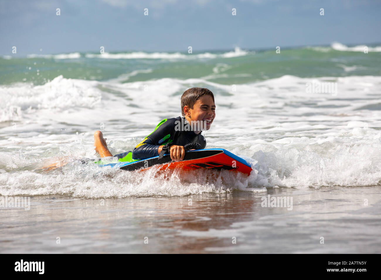 Un giovane ragazzo surf in Pembrokeshire, Galles. Foto Stock