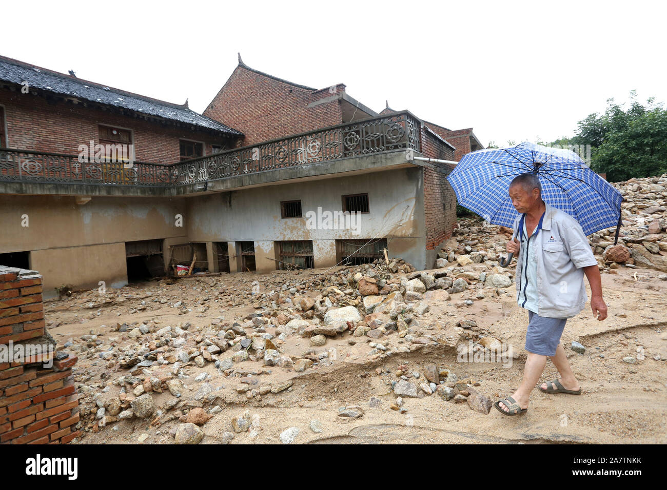 Gli abitanti di un villaggio di controllare la distruzione causata dai torrenti di montagna e prendere la roba ritornare dal distrutto casa nella contea di Lantian, Xi'an City, a nord-ovest della Cina di Foto Stock