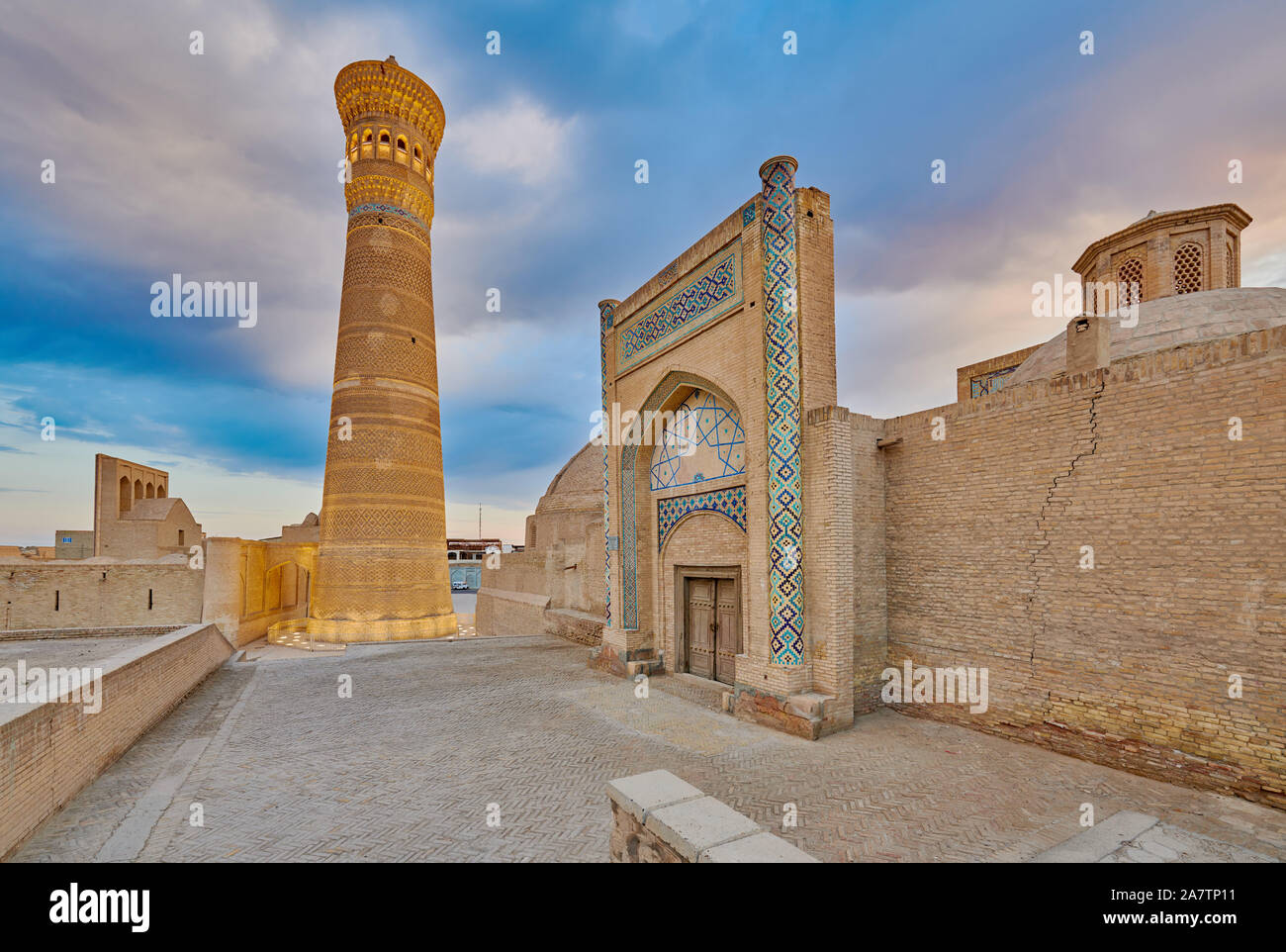 Cancello di ingresso di Amir Alim Khan Madrassa, Kalon o minareto Kaylon dietro , Bukhara, Uzbekistan in Asia centrale Foto Stock