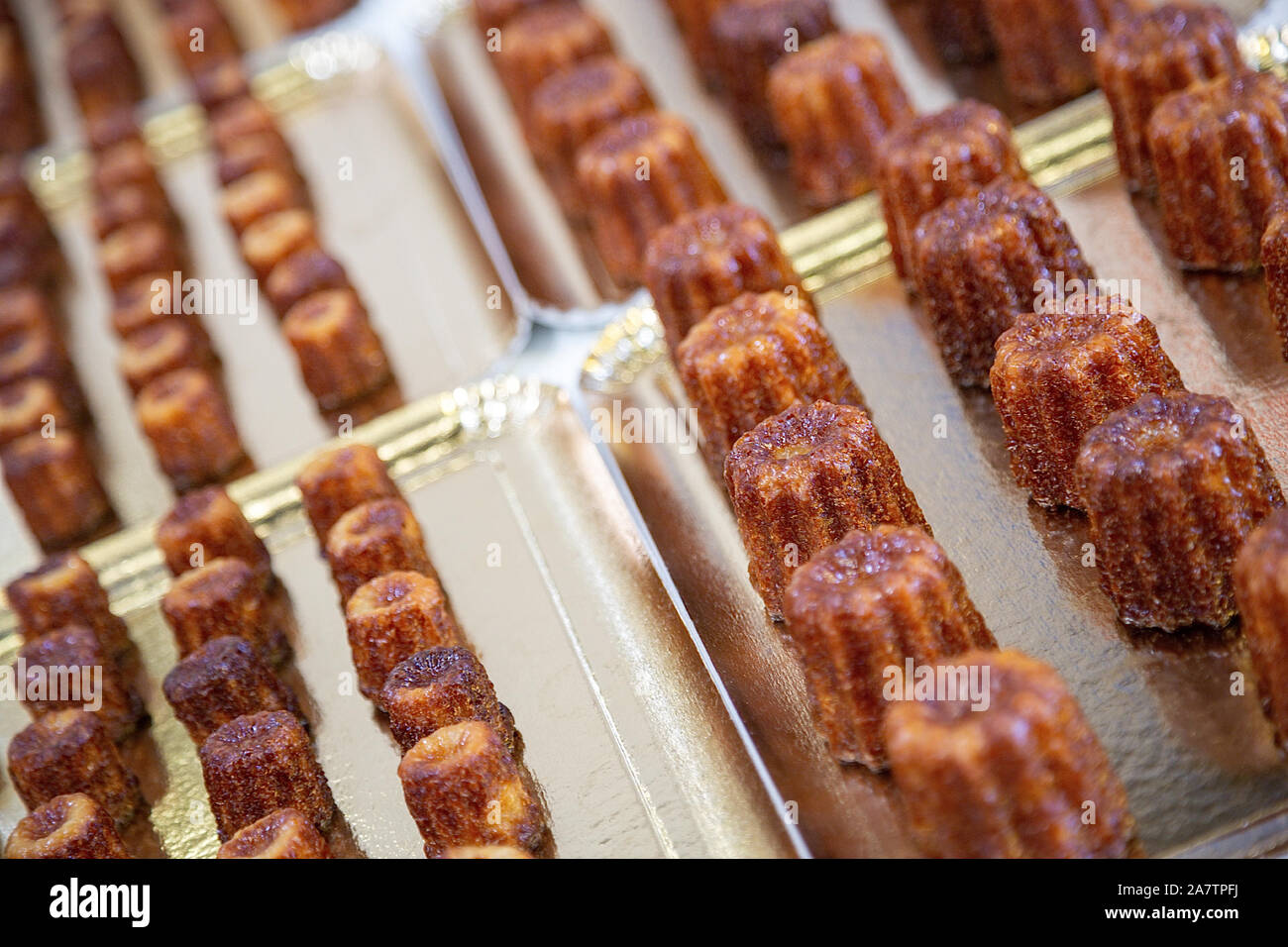 Pieno di cannele posto su una piastra. Cannele è un regionale francese specialità di pasticceria Foto Stock